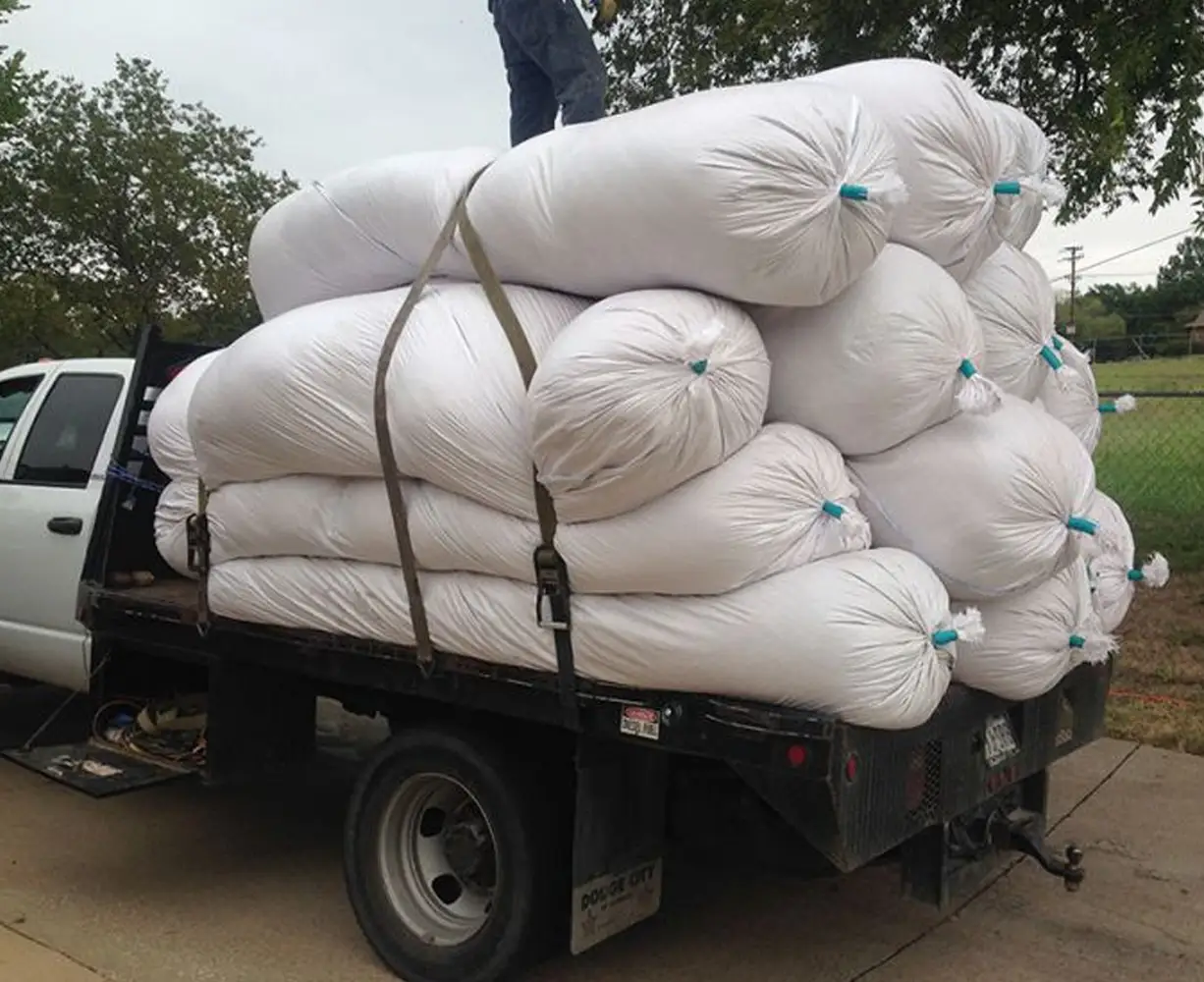 Insulation removal bags stacked on flatbed truck after attic cleanout
