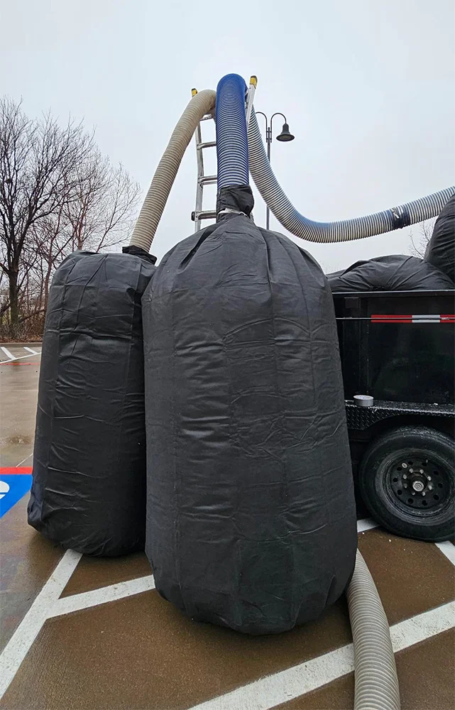 Dust Guard Pro insulation removal bag standing in attic workspace